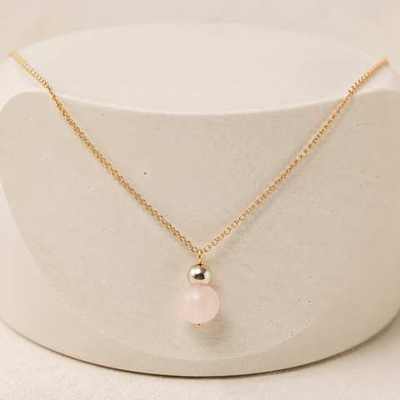 Collar dorado con pequeño colgante rosa